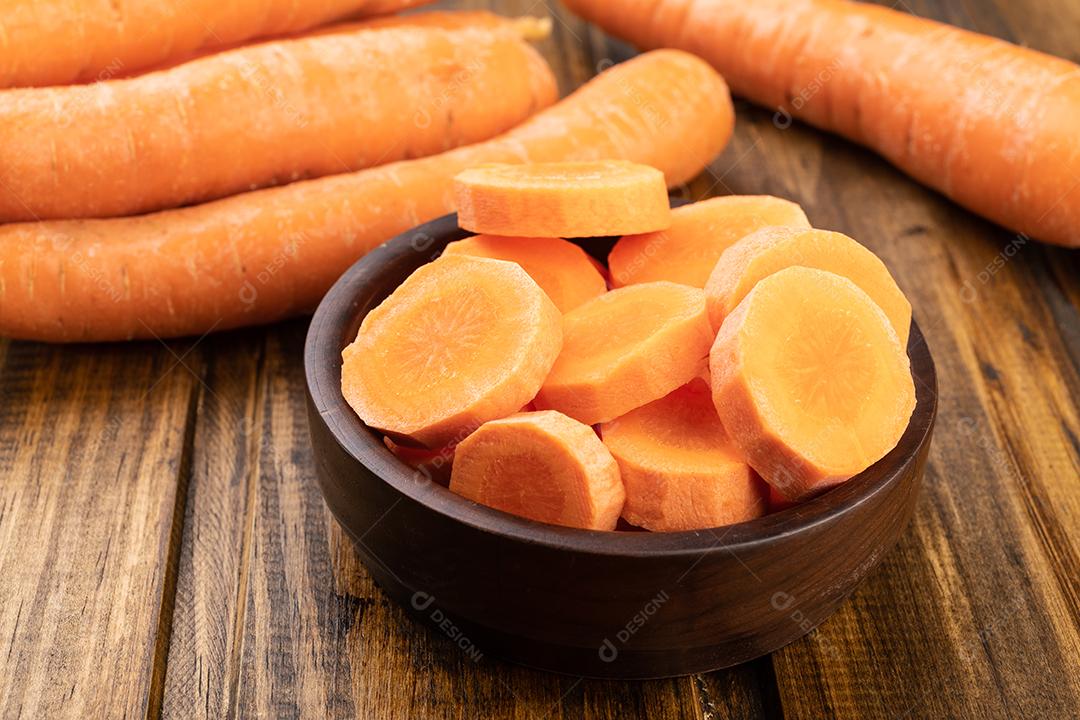 Cenouras e fatias em um prato sobre a mesa de madeira.