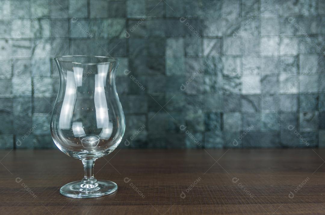 Copo de cerveja elegante vazio na mesa de madeira e fundo de pedra.