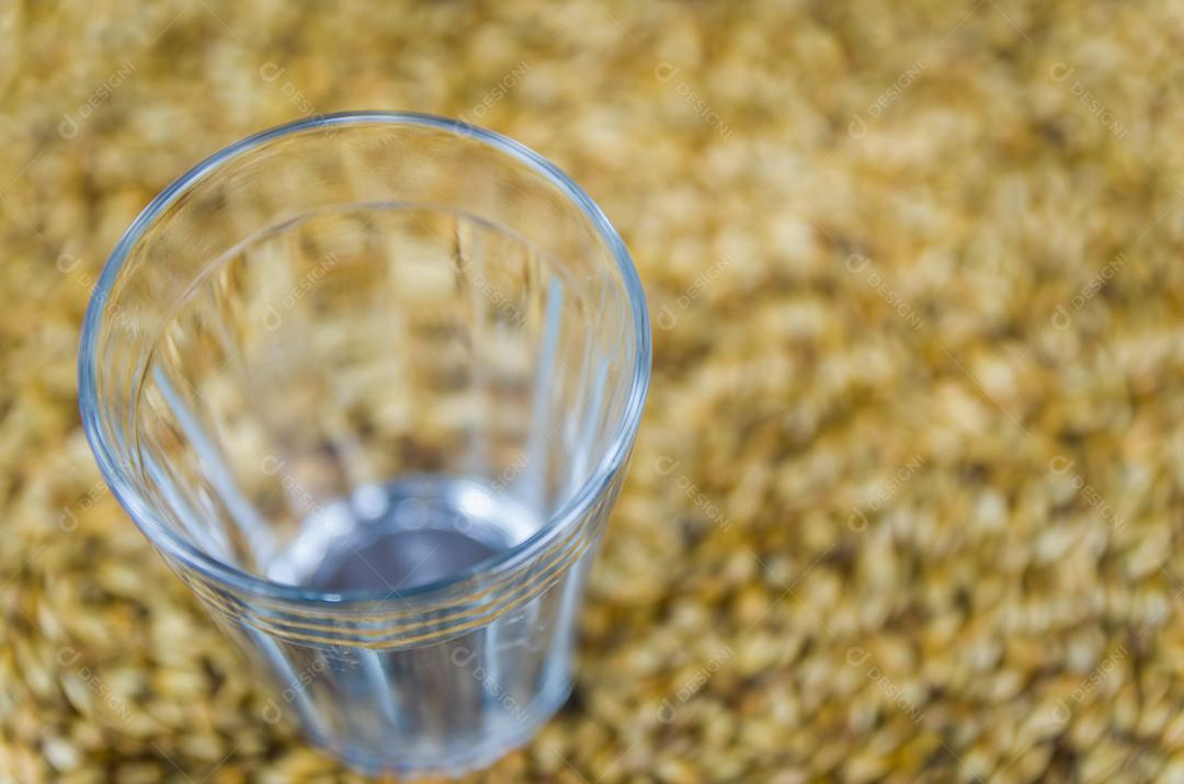 Copo de cerveja visto de cima com malte ao fundo