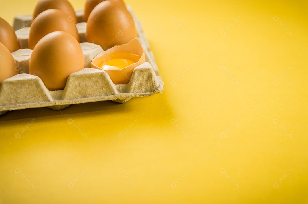 Lindos ovos de galinha marrom fresca sobre fundo amarelo