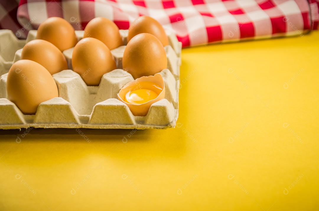 Lindos ovos de galinha marrom fresca sobre fundo amarelo