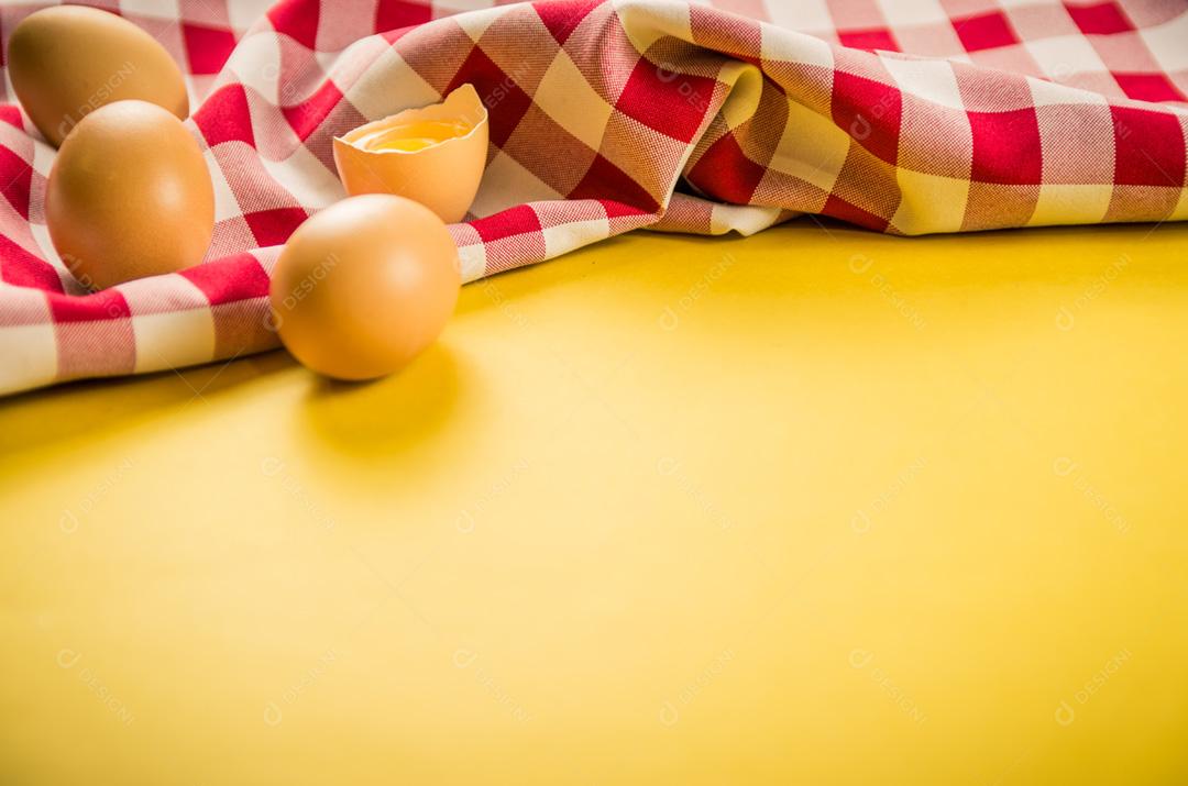 Lindos ovos de galinha marrom fresca sobre fundo amarelo