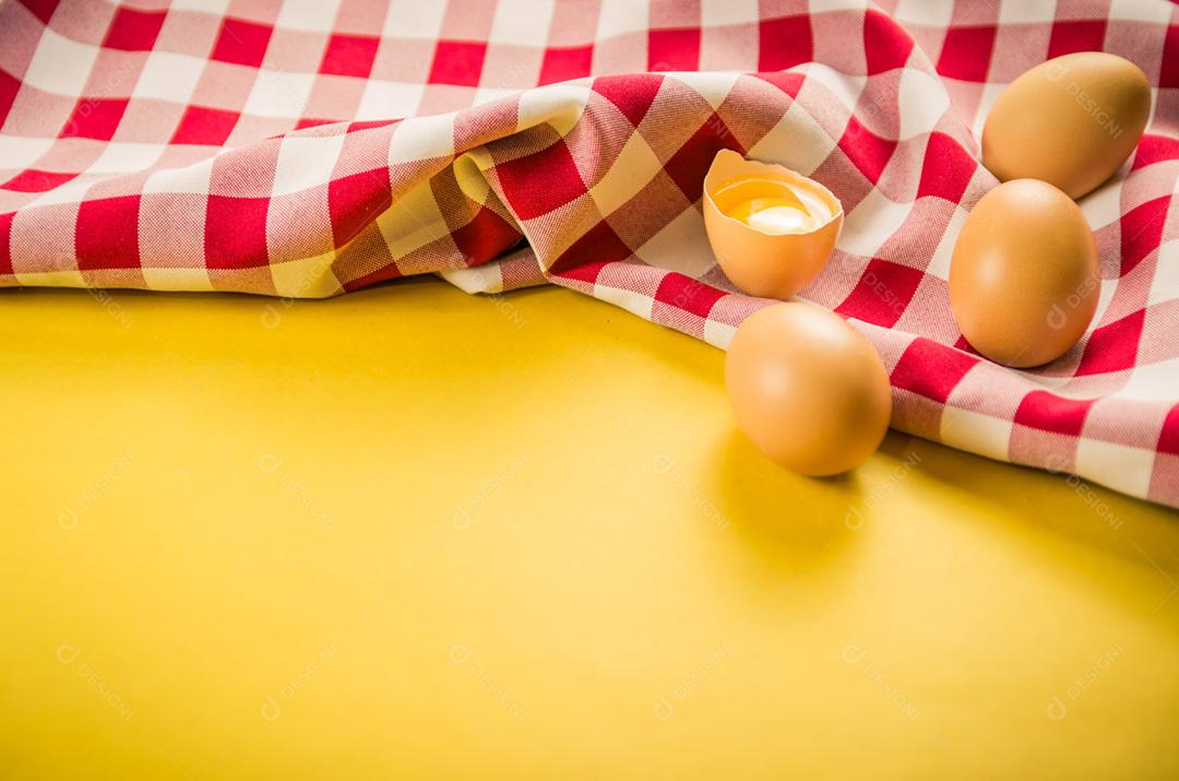 Lindos ovos de galinha marrom fresca sobre fundo amarelo