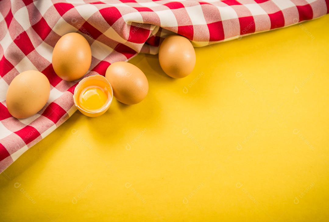 Lindos ovos de galinha marrom fresca sobre fundo amarelo