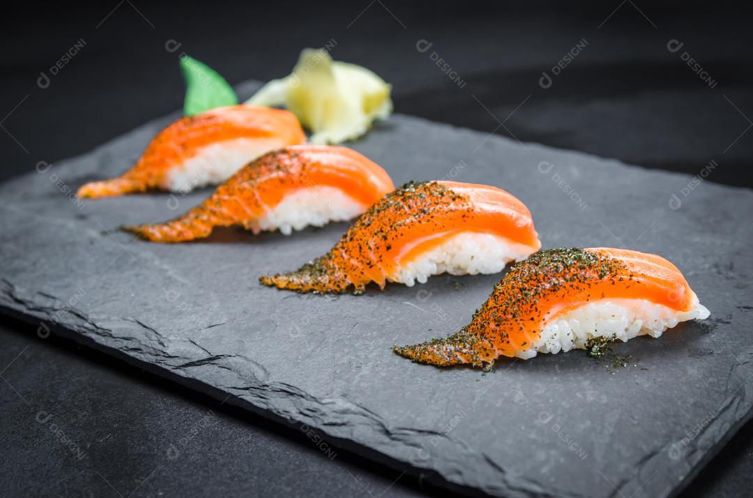 Sushi perfeito, cozinha tradicional japonesa. Delicioso kiguiri de salmão no prato decorado, fundo preto.