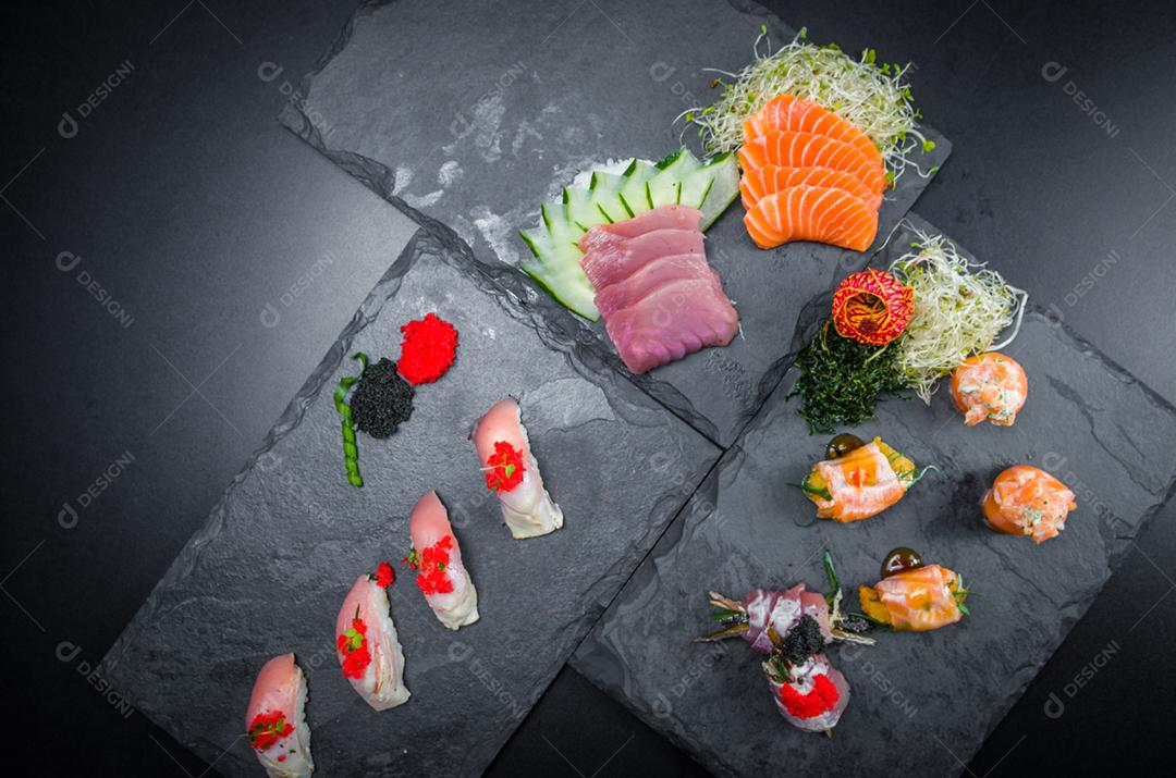 Sushi, cozinha tradicional japonesa. Vários deliciosos sushis no prato decorado, fundo preto