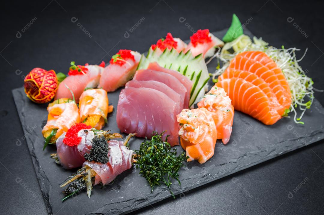 Sushi, cozinha tradicional japonesa. Vários deliciosos sushis no prato decorado, fundo preto