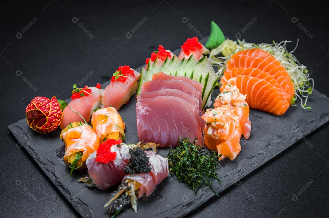 Sushi, cozinha tradicional japonesa. Vários deliciosos sushis no prato decorado, fundo preto