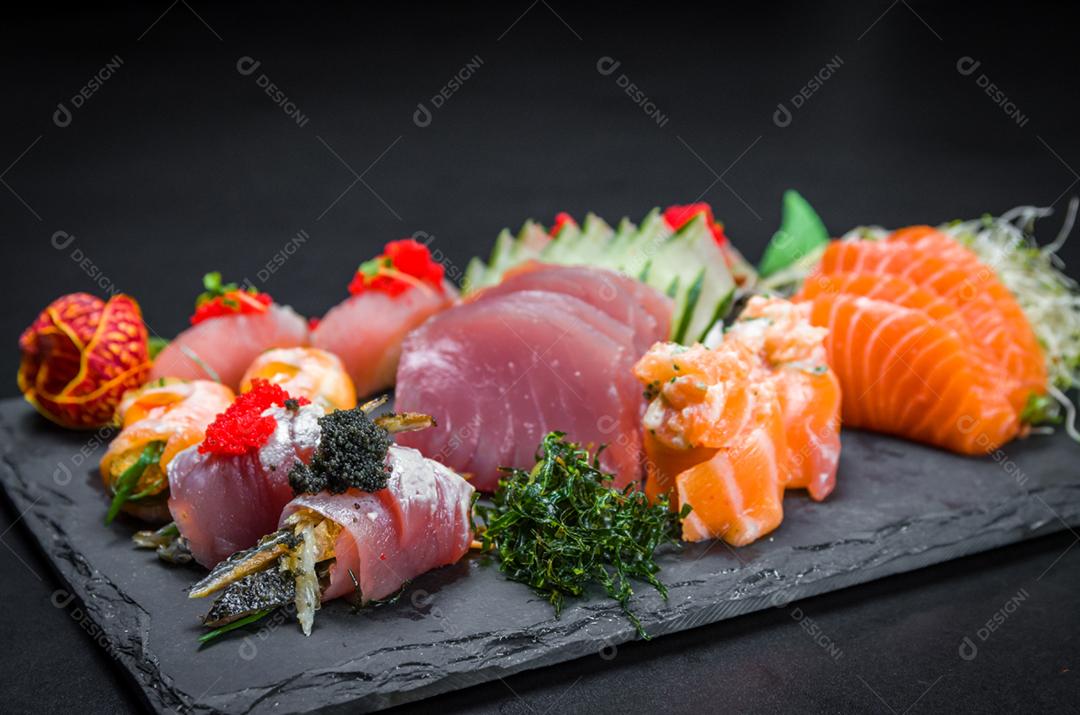 Sushi, cozinha tradicional japonesa. Vários deliciosos sushis no prato decorado, fundo preto