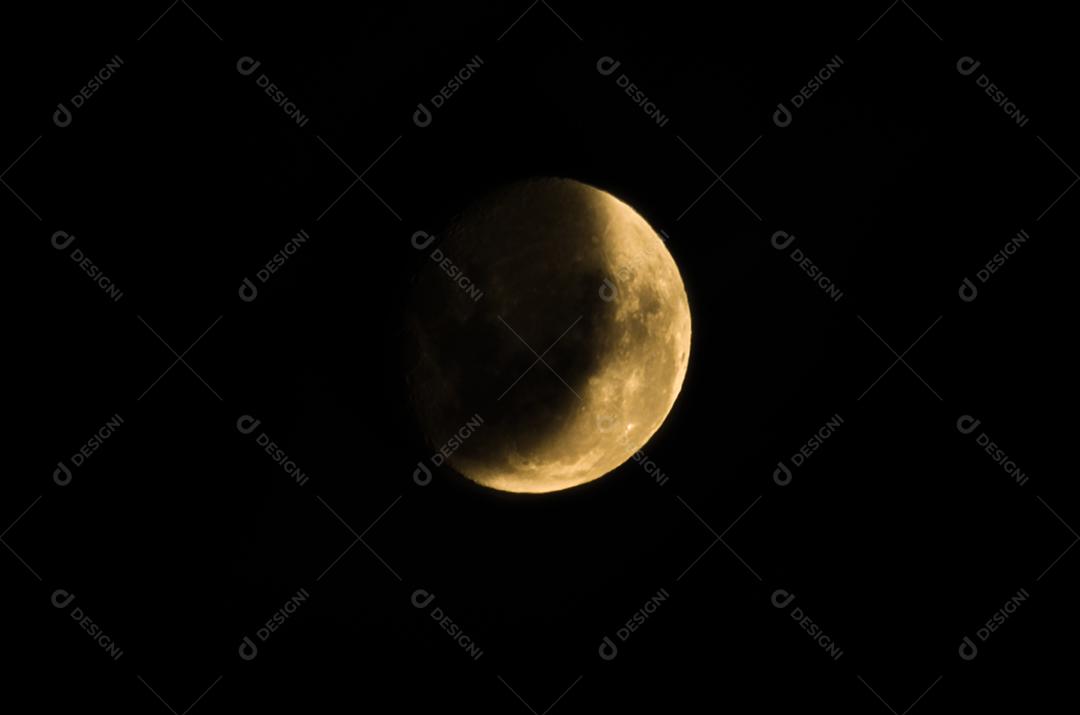 Linda foto da lua minguante em com céu escuro ao fundo.