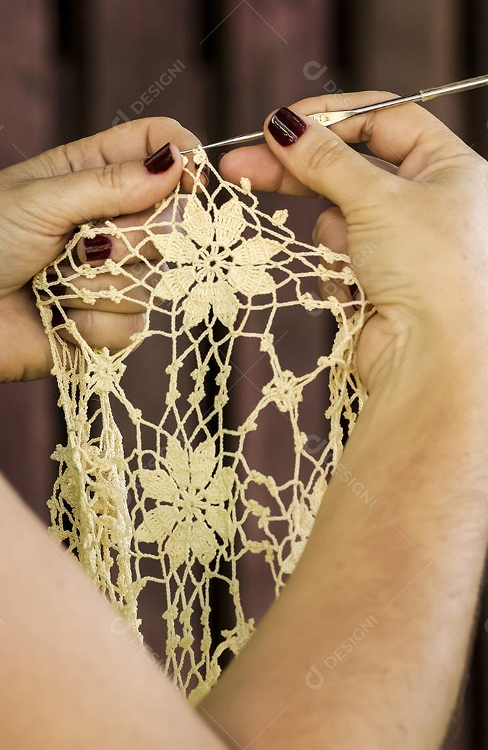 Crochê de renda brasileiro feito à mão. Mãos de artesão de close-up de crochê.