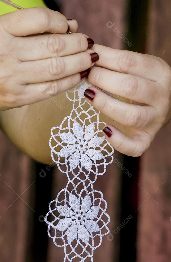 Crochê de renda brasileiro feito à mão. Mãos de artesão de close-up de crochê.