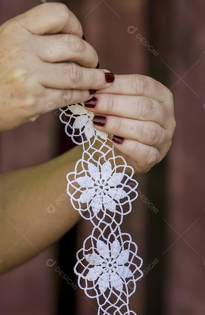 Crochê de renda brasileiro feito à mão. Mãos de artesão de close-up de crochê.