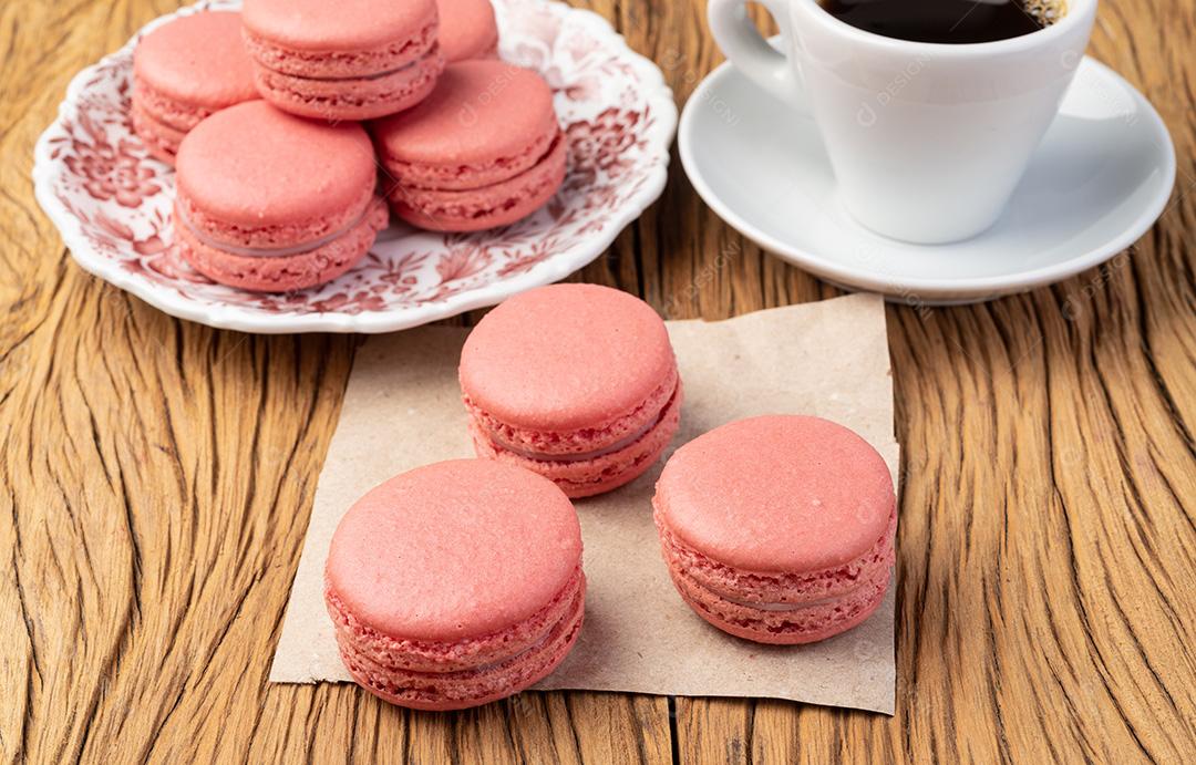 Macarons de Berry em um prato com café sobre a mesa de madeira