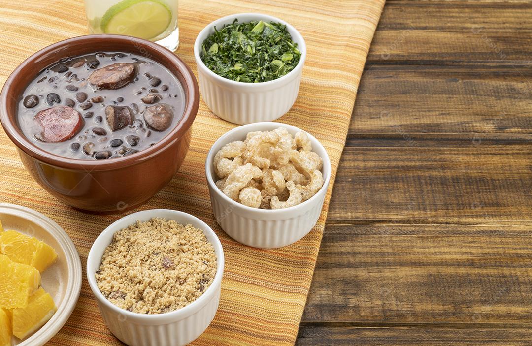 Tradicional feijoada brasileira com farinha de mandioca, couve, caipirinha