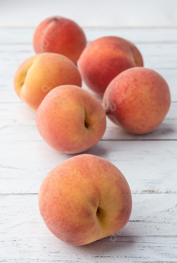 Um grupo de pêssegos sobre a mesa de madeira.