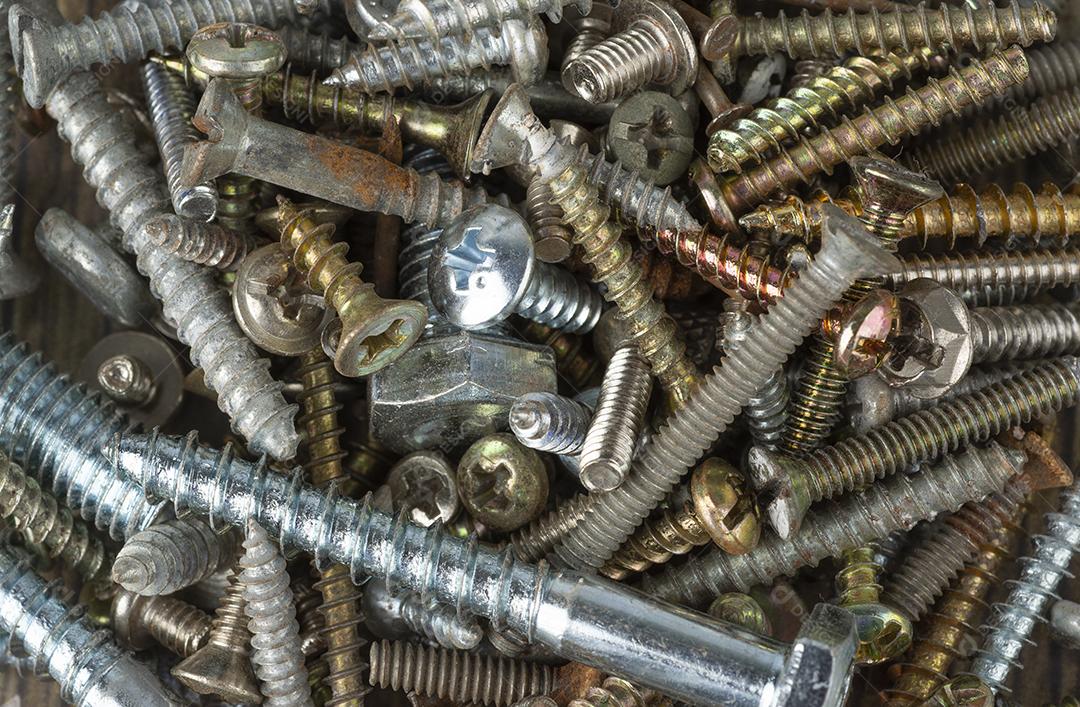 Vista de perto de cima de parafusos e parafusos velhos.