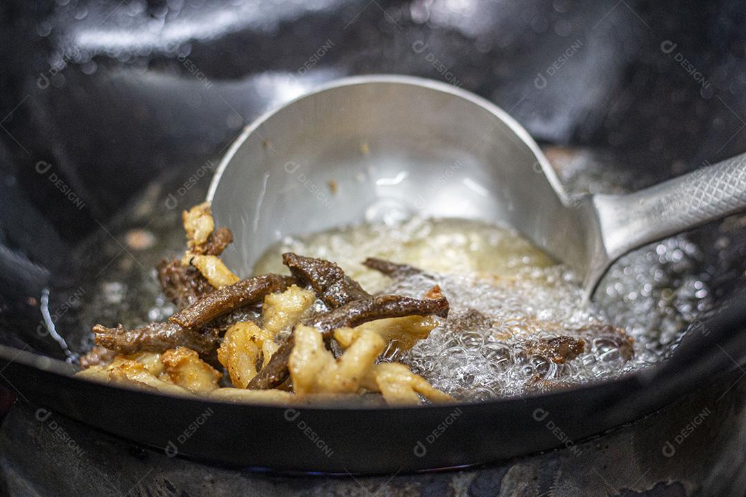 Fritando bacon e torres em óleo fervente.