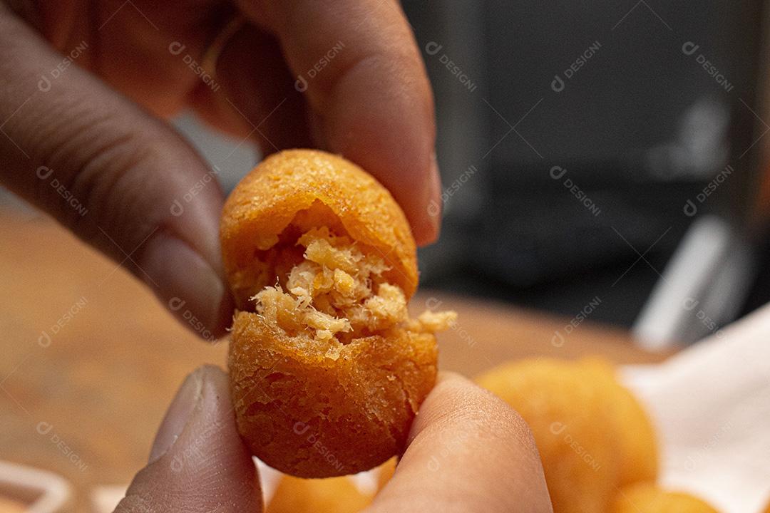 Salgadinho de frango sobre tigela branca.