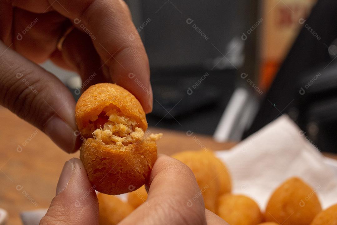 Salgadinho de frango sobre tigela branca.