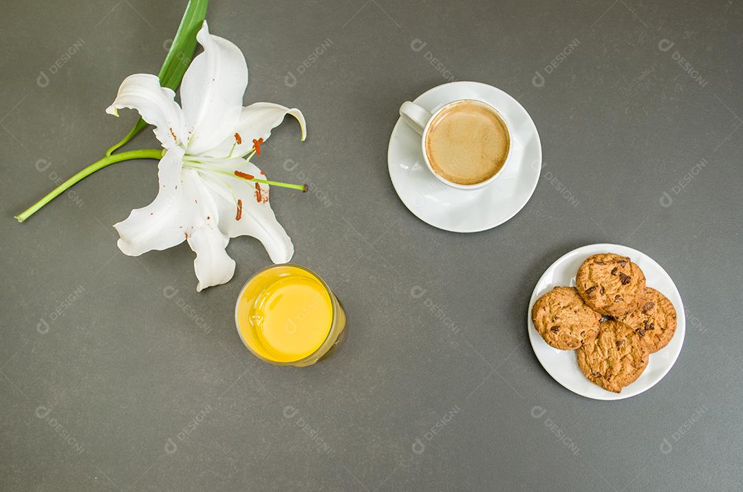 Mesa posta, café , biscoitos e suco flor lirio com fundo escuro