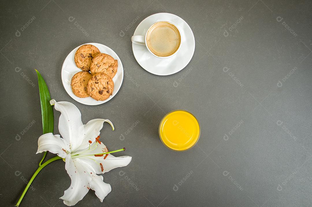 Mesa posta, café , biscoitos e suco flor lirio com fundo escuro