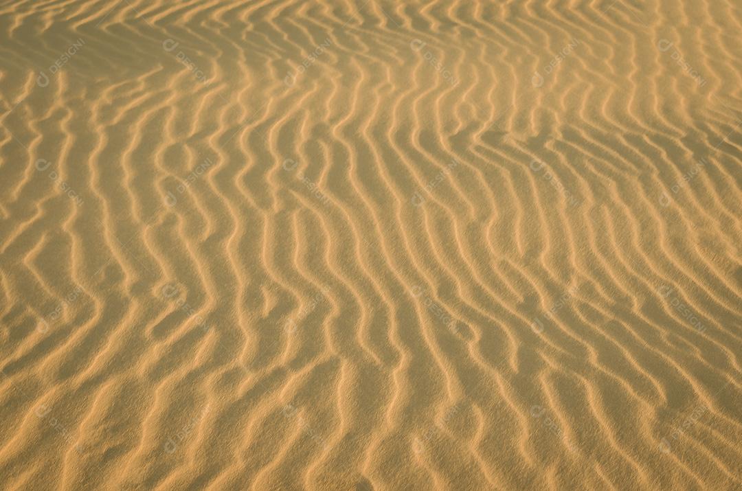 Areia ondulada seca e leve na praia com ondas sob a vista de perspectiva de close-up da luz solar de verão brilhante, fundo de ilustração 3D da natureza