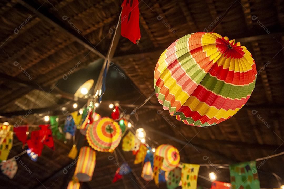 Bandeiras tradicionais e lanternas das festividades juninas no Nordeste do Brasil. Fundo colorido