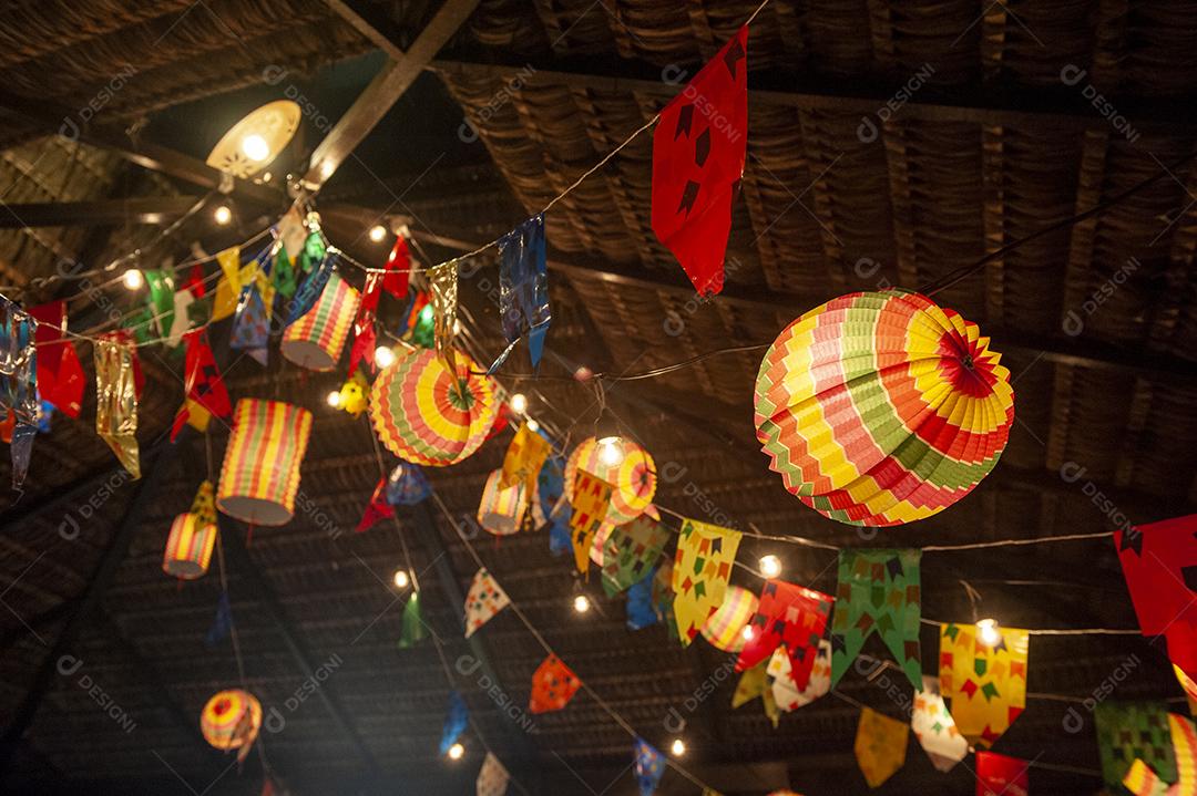 Bandeiras tradicionais e lanternas das festividades juninas no Nordeste do Brasil. Fundo colorido