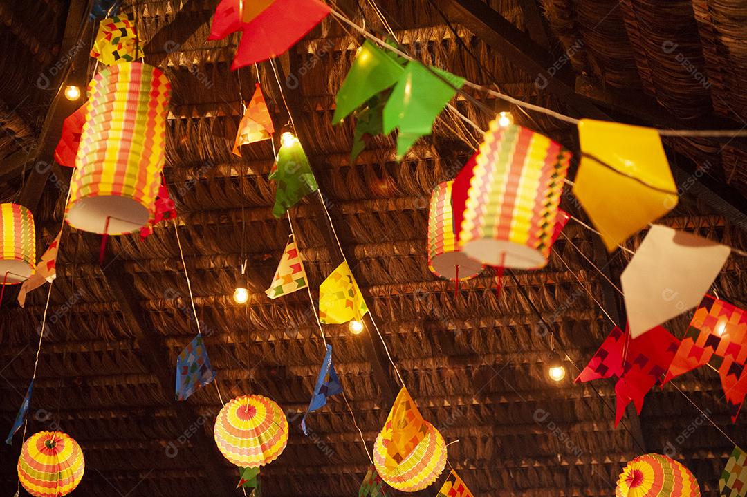 Bandeiras tradicionais e lanternas das festividades juninas no Nordeste do Brasil. Fundo colorido
