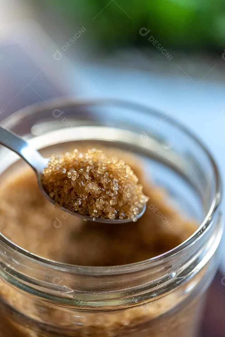 Organic brown sugar spoon in glass sugar bowl.