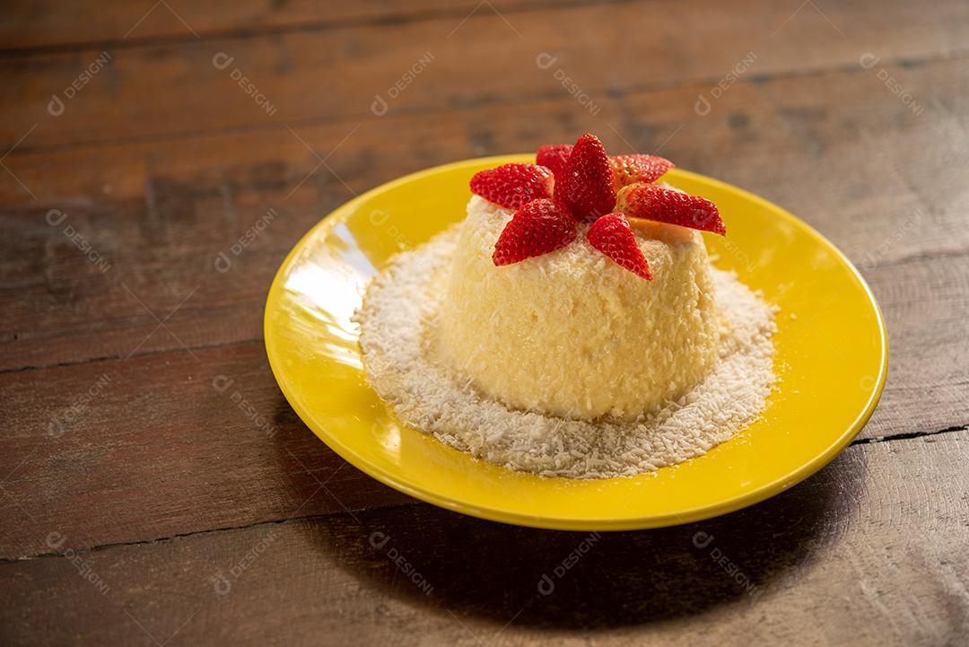 Massa de tapioca e bolo de coco, decorado com morangos, servido na mesa com café. Gastronomia, sobremesa.