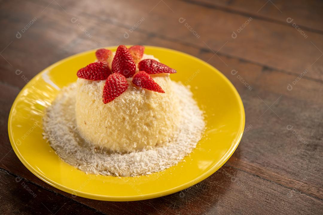 Massa de tapioca e bolo de coco, decorado com morangos, servido na mesa com café. Gastronomia, sobremesa.