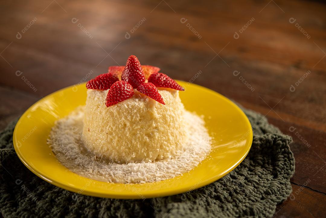 Massa de tapioca e bolo de coco, decorado com morangos, servido na mesa com café. Gastronomia, sobremesa.