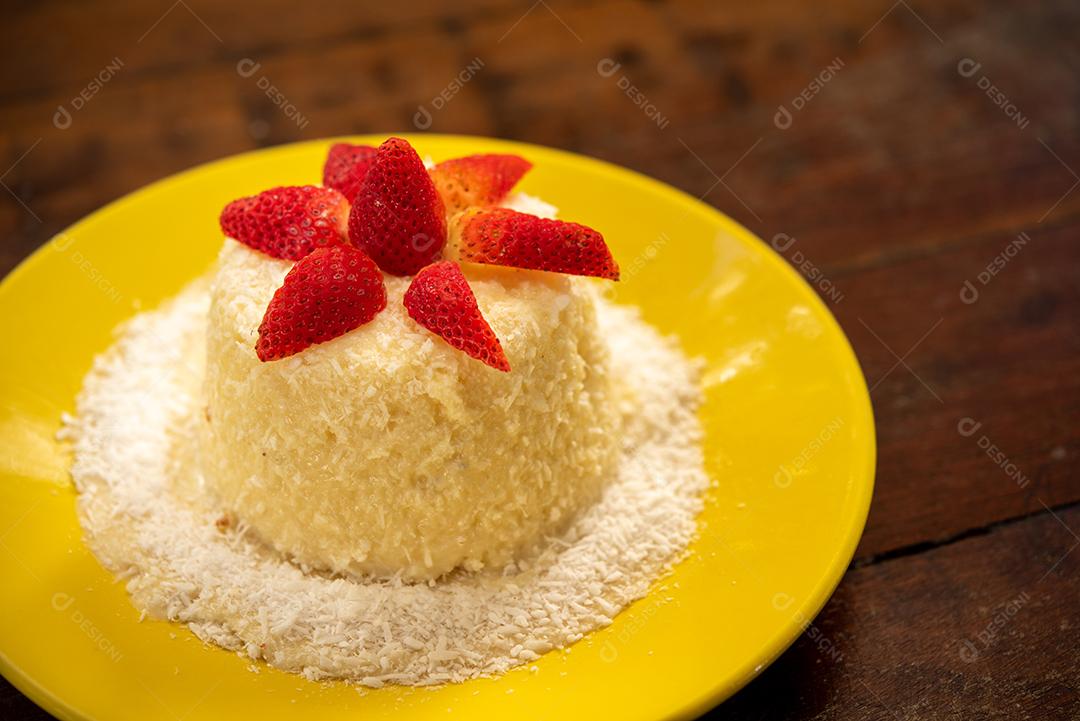 Massa de tapioca e bolo de coco, decorado com morangos, servido na mesa com café. Gastronomia, sobremesa.