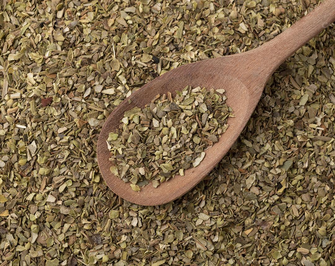 Vista superior, orégano seco em uma colher de madeira.