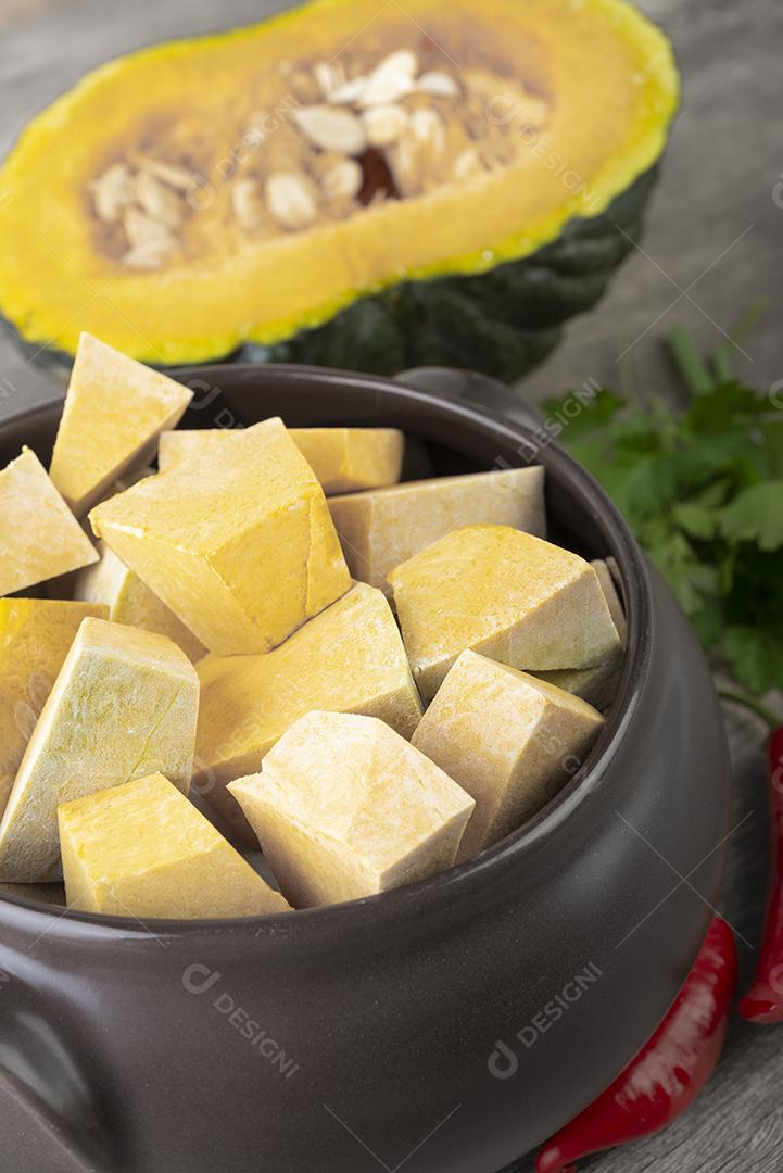 Abobora pedaços em uma tigela com meia fruta