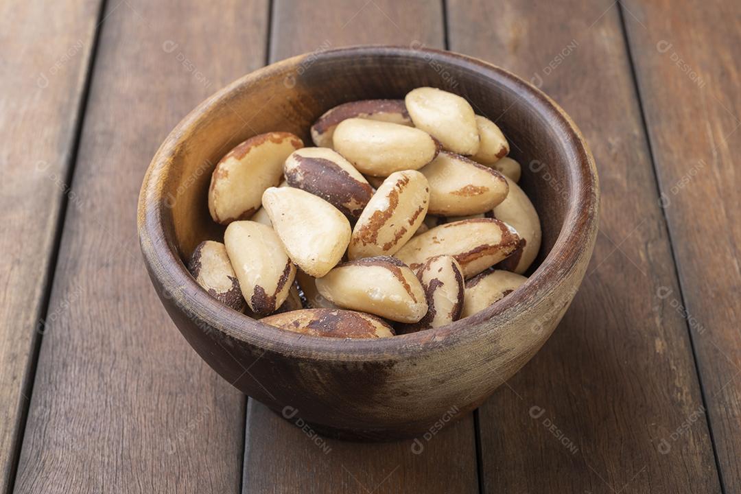 Castanha-do-pará em uma tigela sobre mesa de madeira.