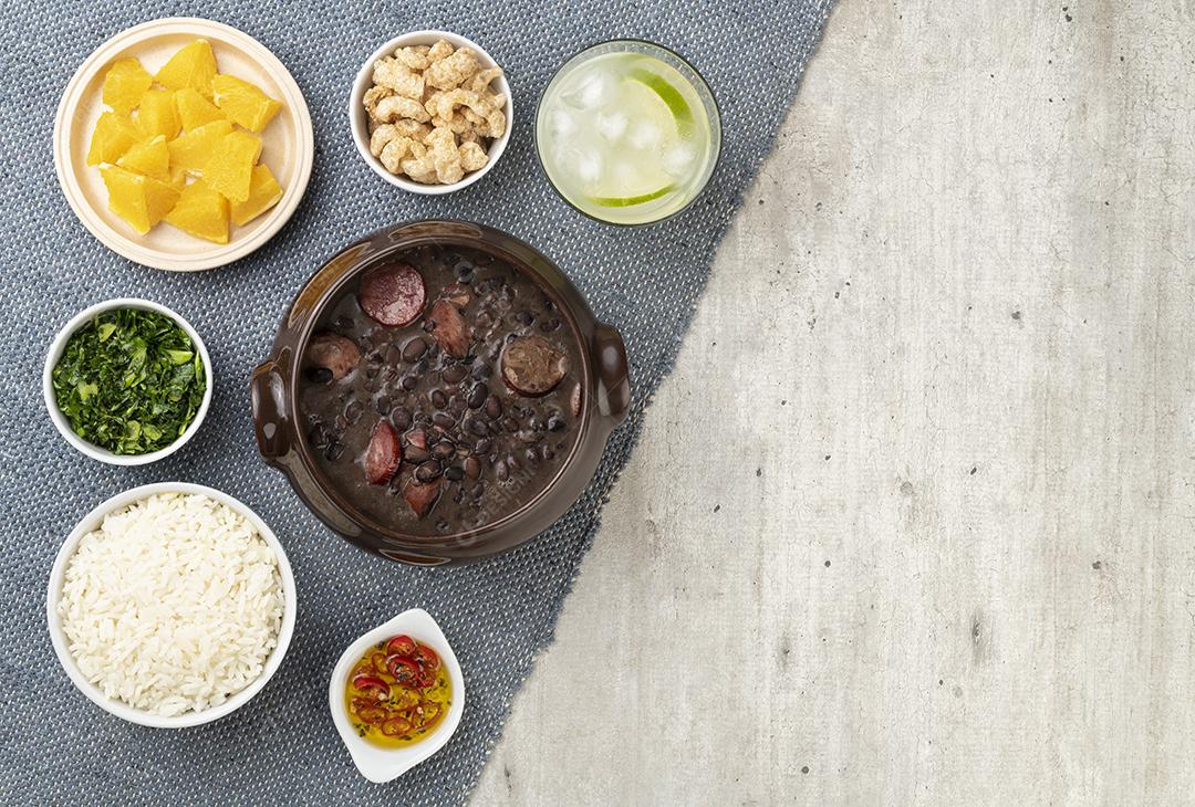 Tradicional feijoada brasileira com arroz, couve, caipirinha, laranja