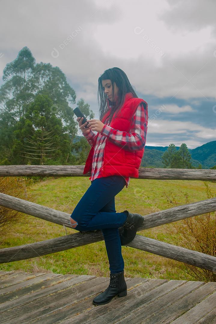 Jovem linda mechendo em seu celular