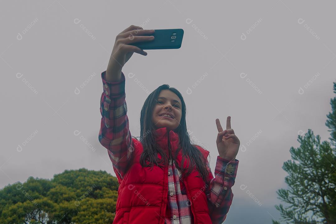 Jovem linda mechendo em seu celular