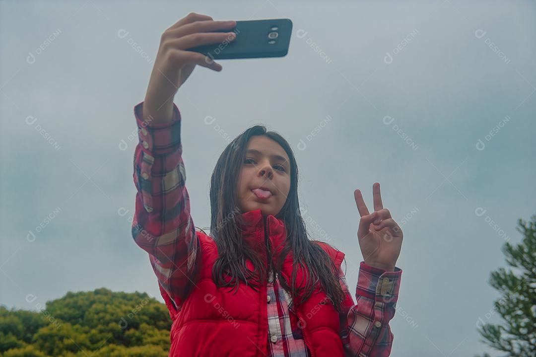 Jovem linda mechendo em seu celular