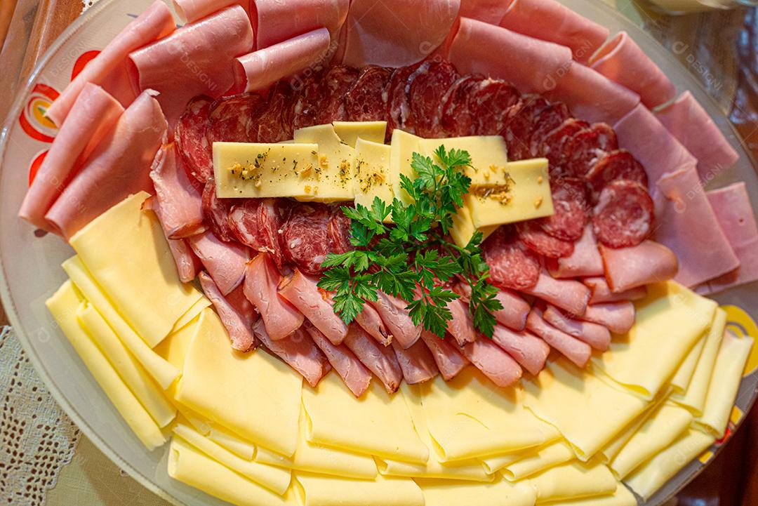 Café da manhã farto servido com bolos, tortas, geléias, bolos, queijo, presunto, café, leite.