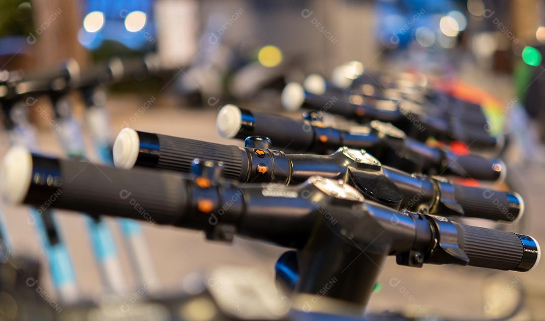 Patinetes modernos de chute elétrico estacionados na rua da cidade à noite. Conceito de transporte alternativo ecológico - Foco Seletivo