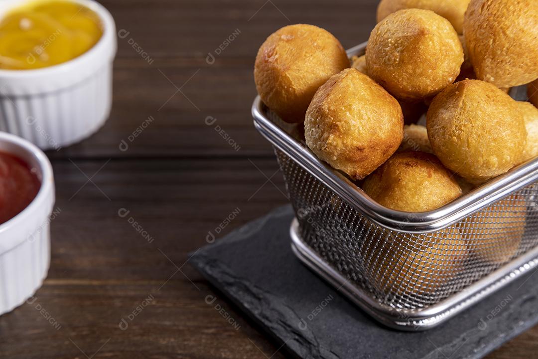 Salgado em uma saco de papel e ketchup sobre mesa madeira