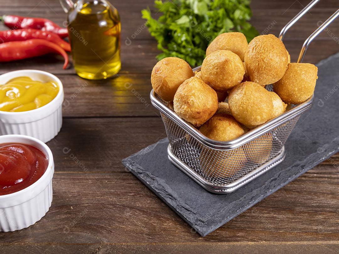 Salgado em uma saco de papel e ketchup sobre mesa madeira