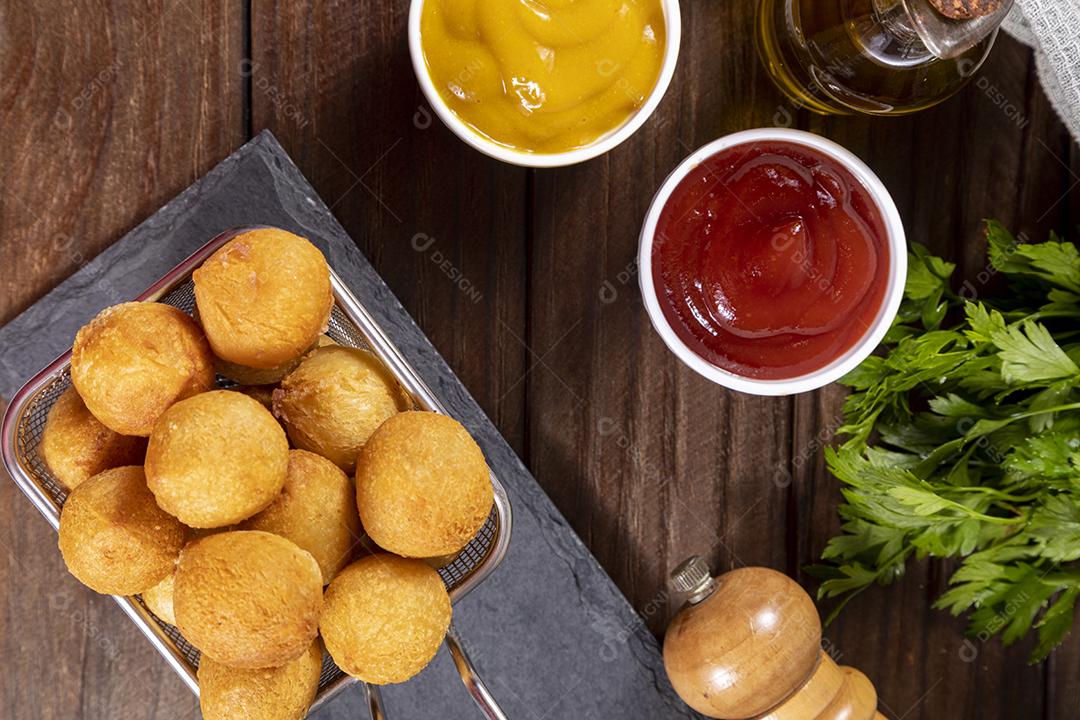 Salgado em uma saco de papel e ketchup sobre mesa madeira