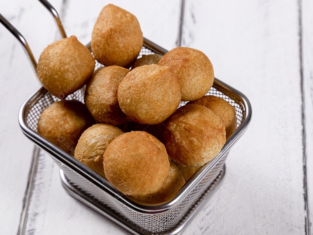 Salgados e ketchup em uma cesta com papel sobre mesa branca isolada