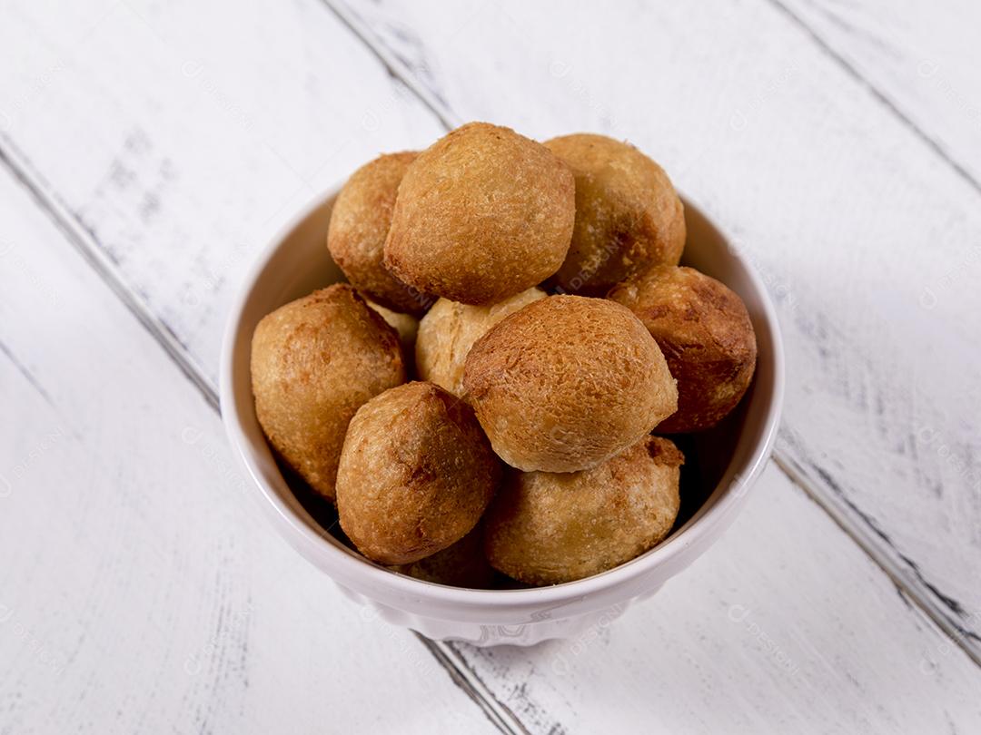 Salgados e ketchup em uma cesta com papel sobre mesa branca isolada