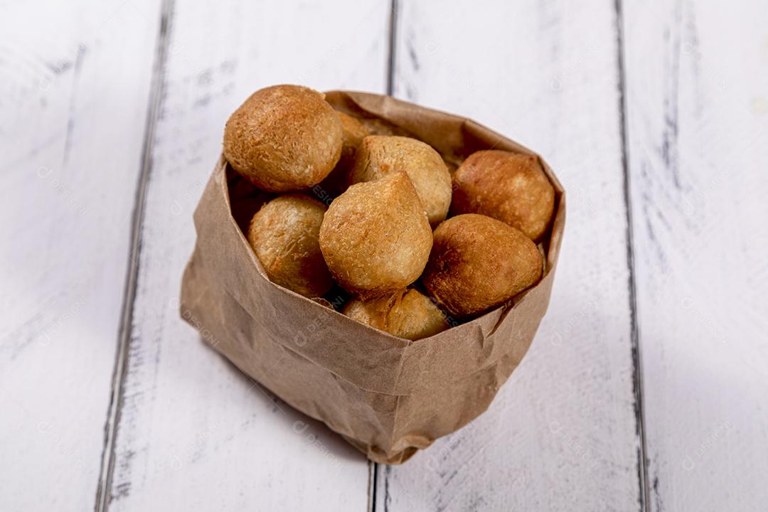 Salgados e ketchup em uma cesta com papel sobre mesa branca isolada